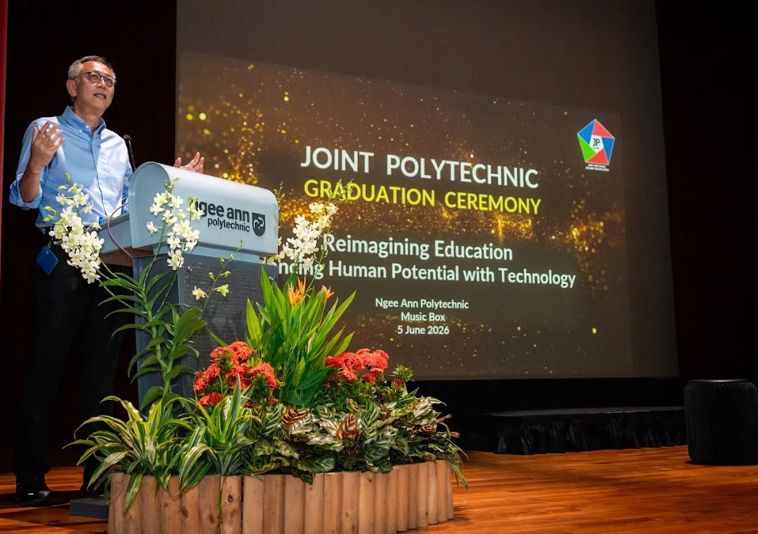 PCEO/NP gives his opening speech infront of a podium.