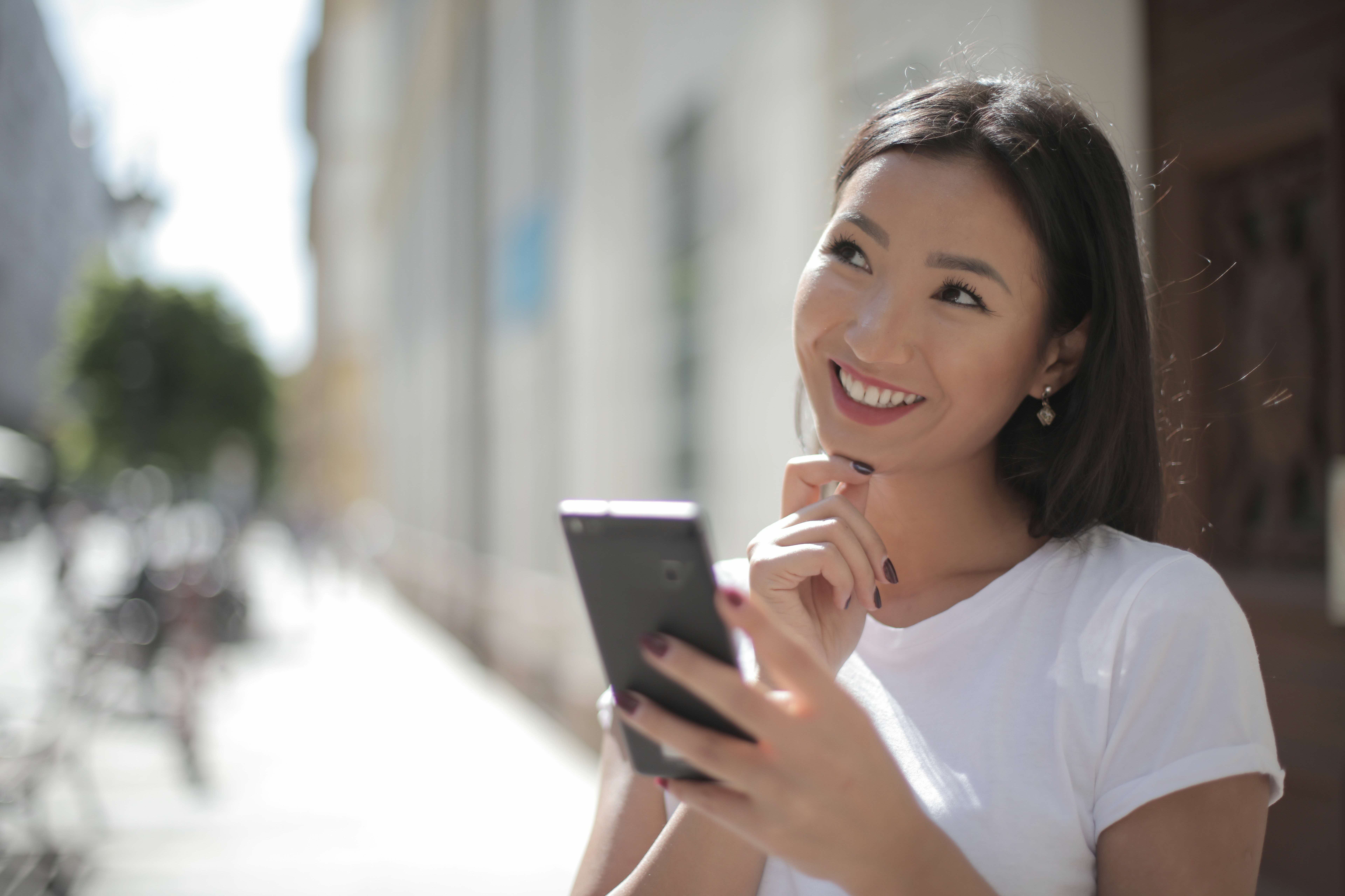 Person holding phone and smiling