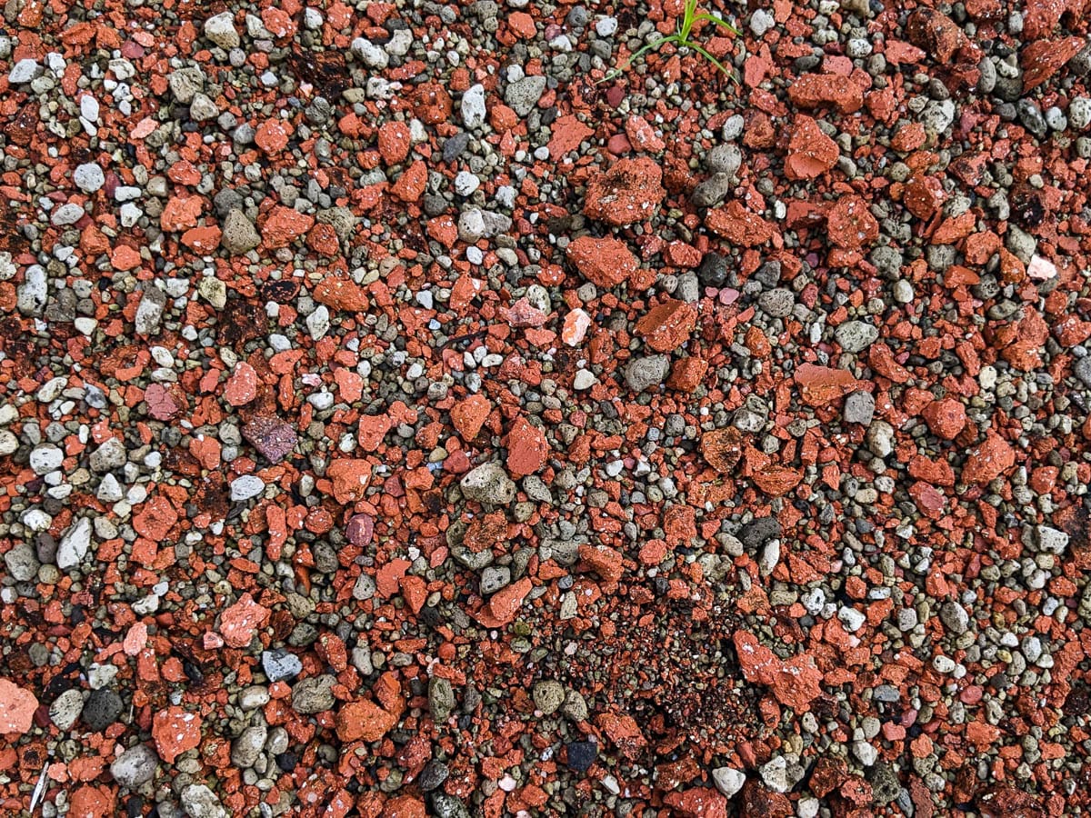 Close up of orangey burnt earth mixed with other coarse particles