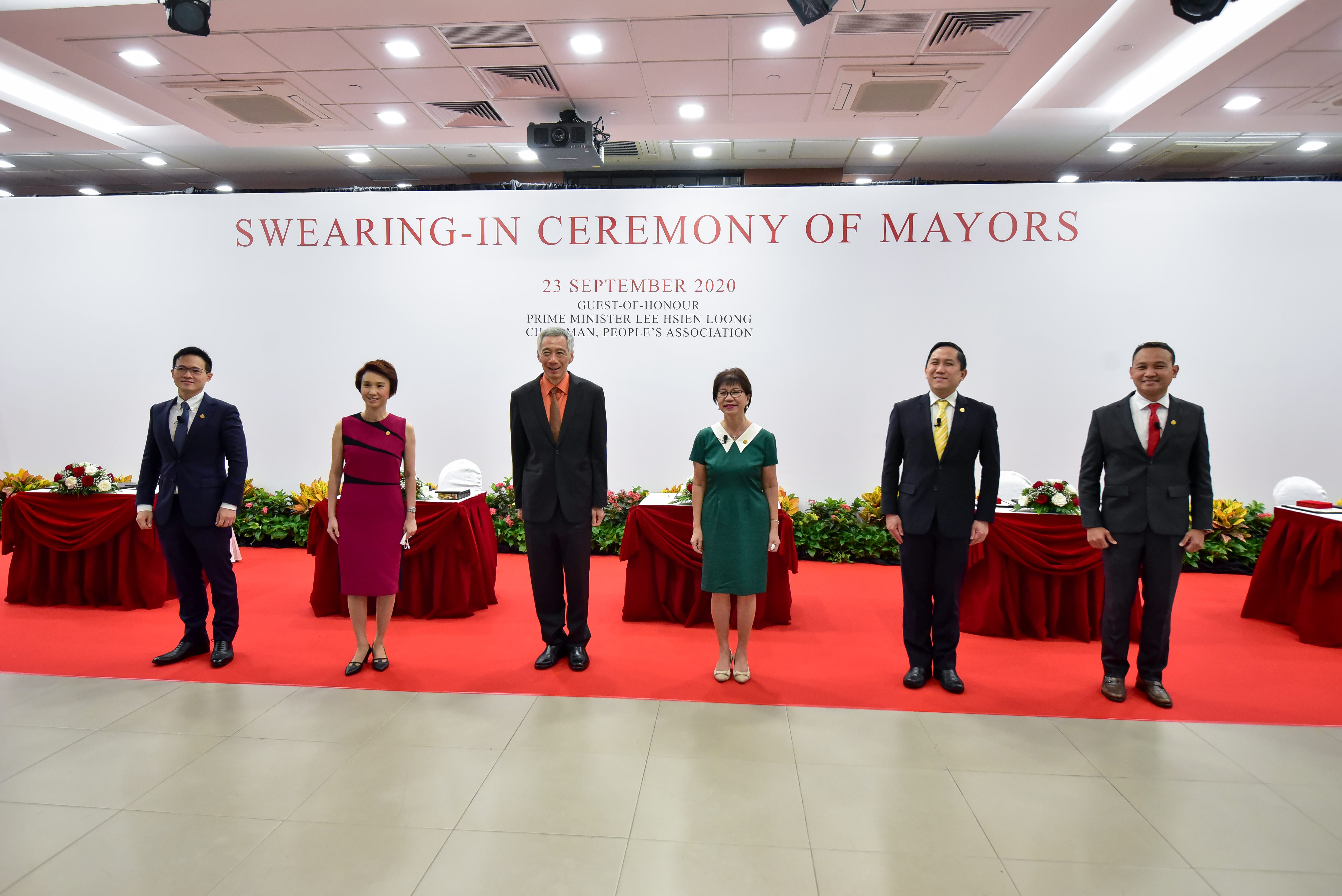 Six individuals stand on a red carpet at a "Swearing-in Ceremony of Mayors" held on 23 September 2020.