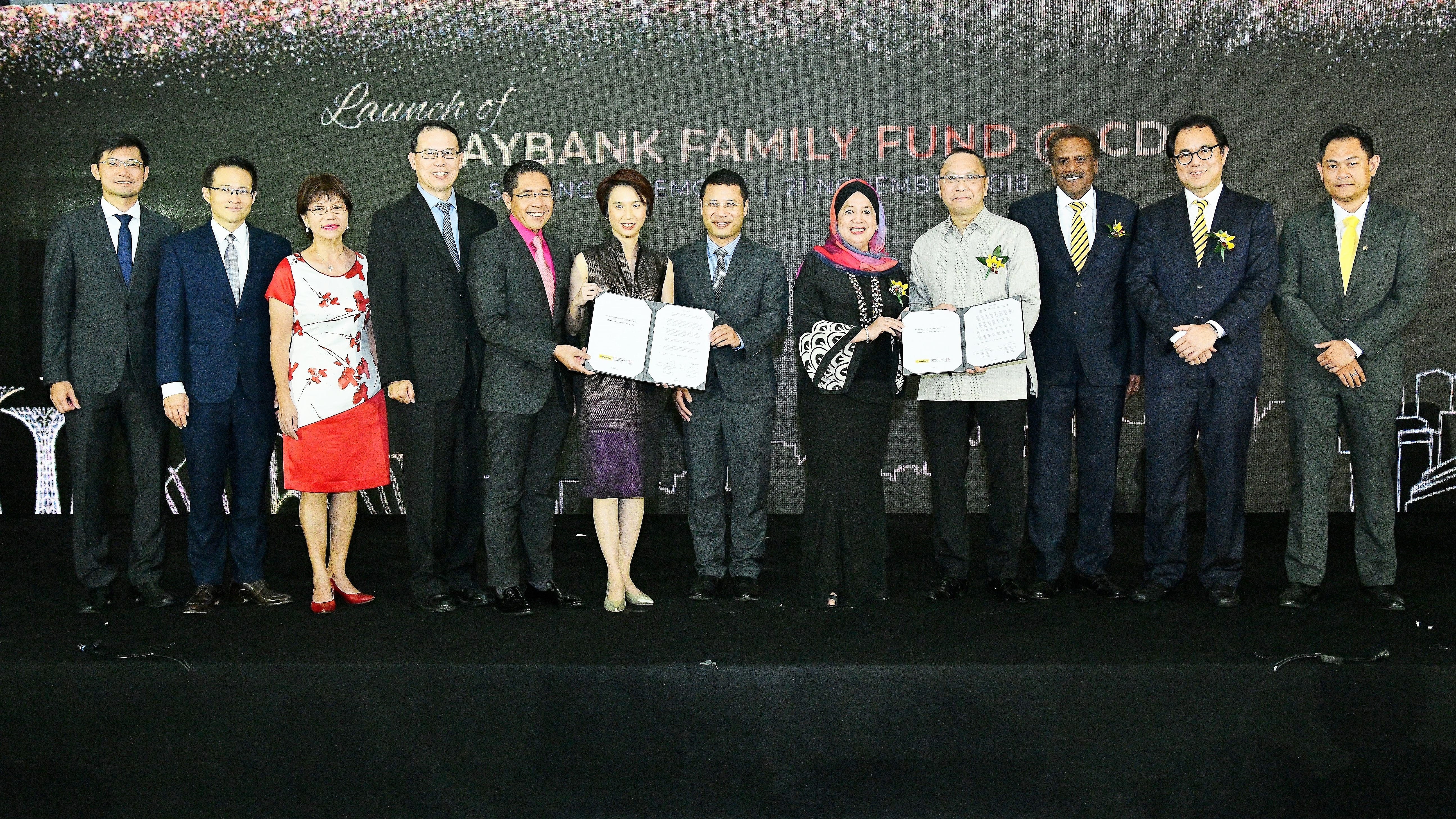 Group photo of ten people standing on a stage holding certificates at the launch of Maybank Family Fund.