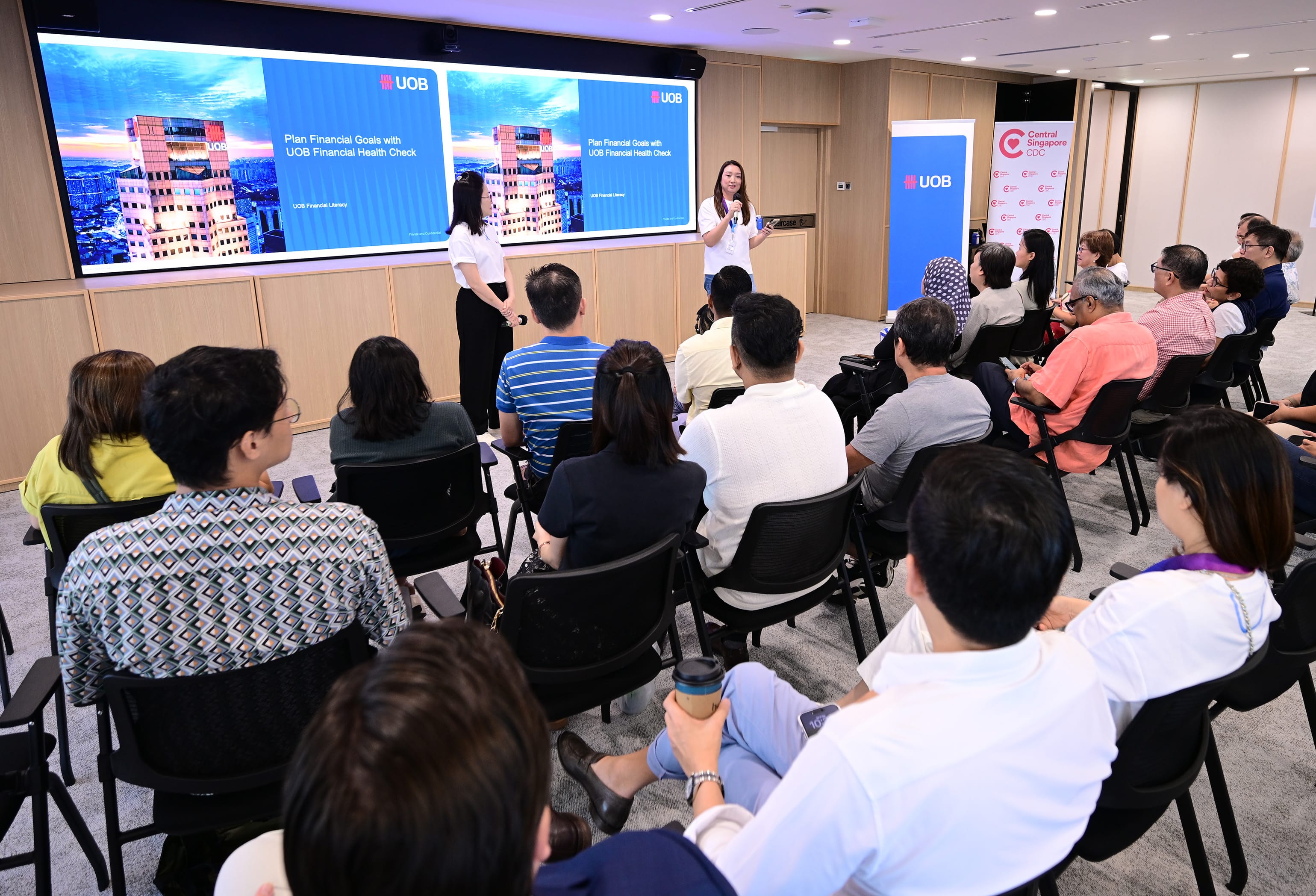 An image showcasing participants attending the financial fitness workshops. The participants are listening to the two presenters from UOB.