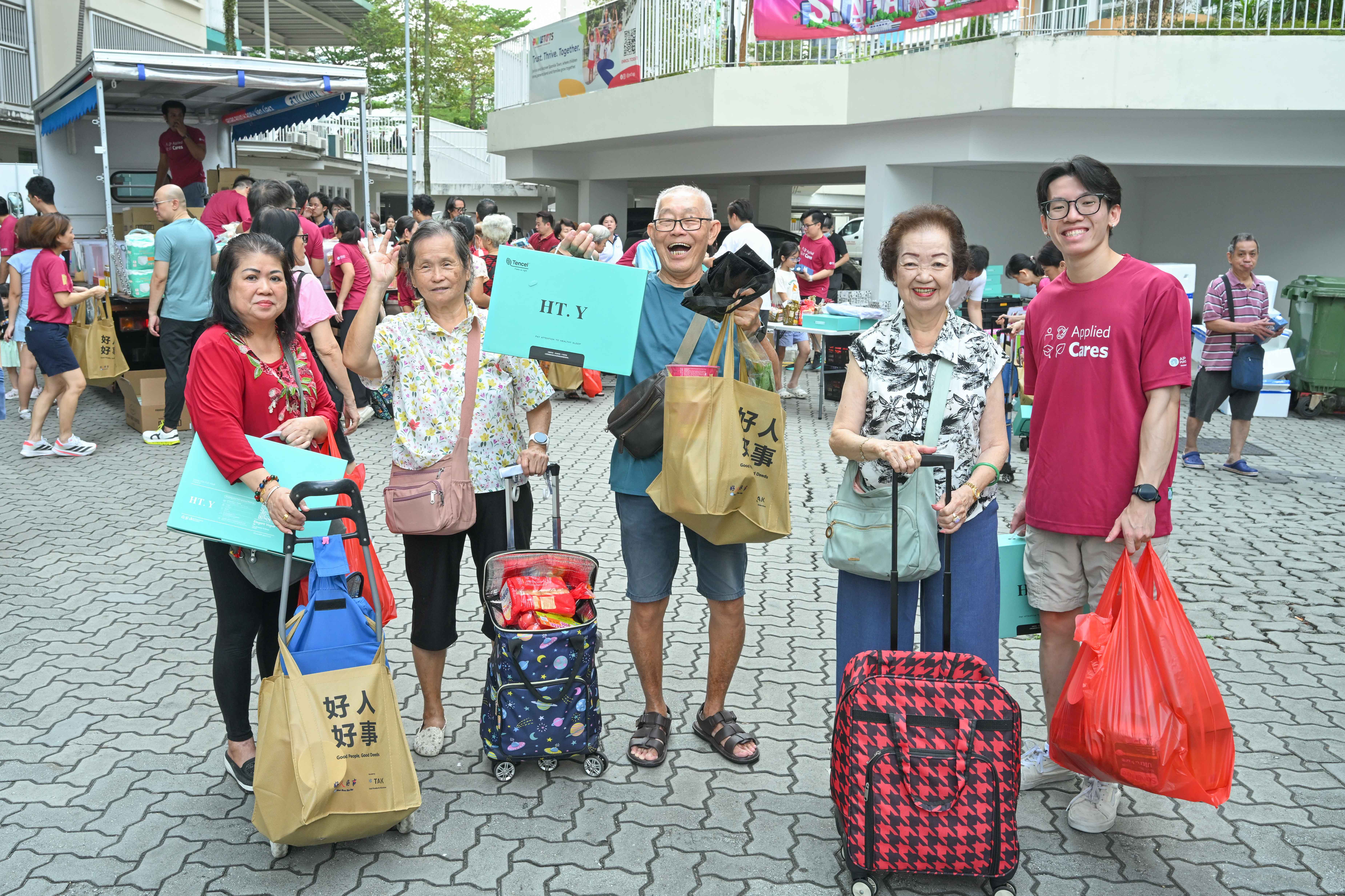 Elderlies pose after receiving groceries