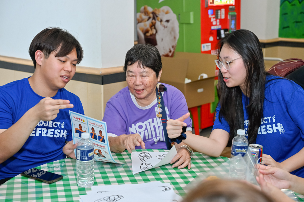 Volunteers imparting sign language to a senior