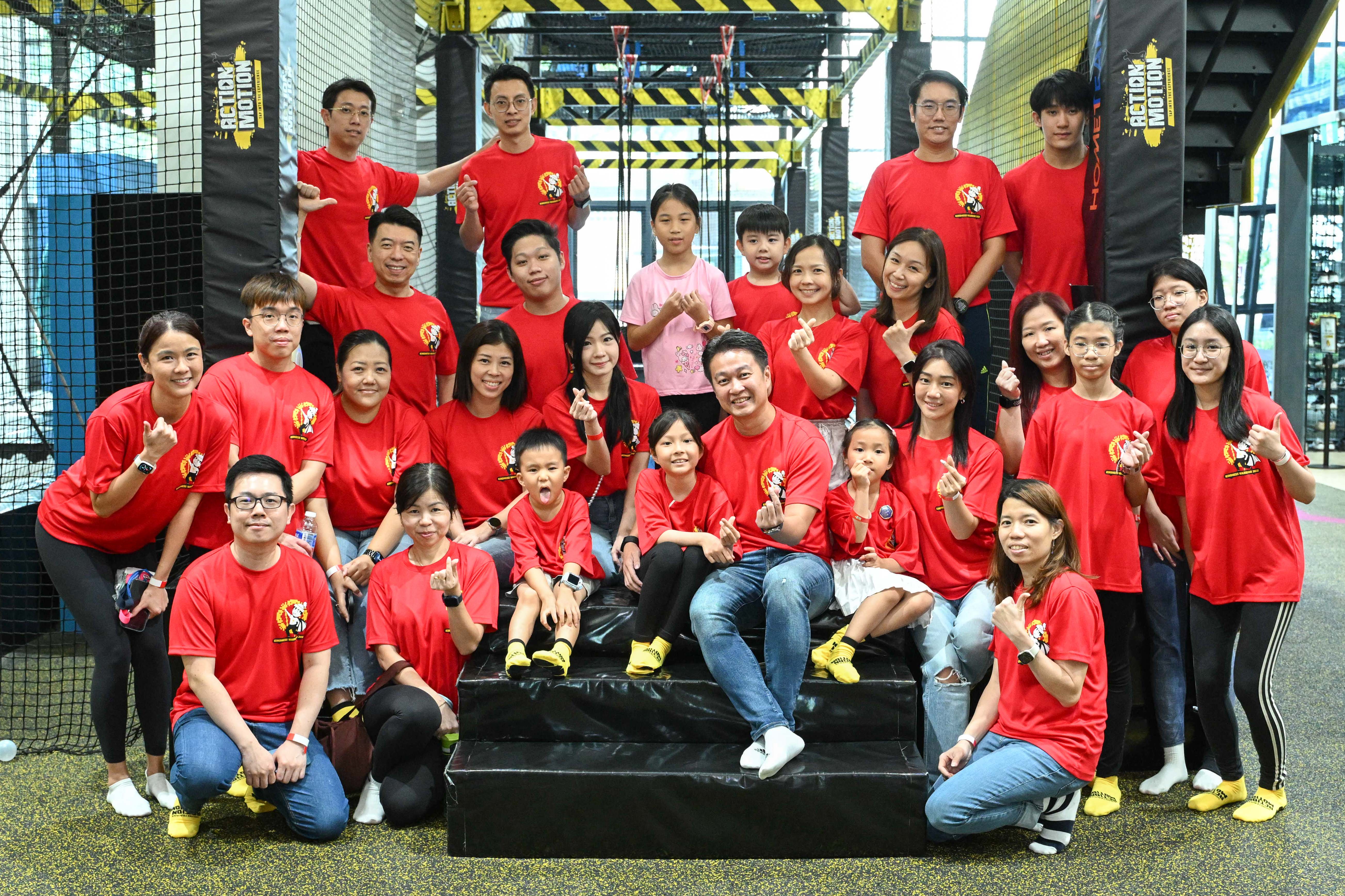 Group photo of families and participants at the Climb for School Transport event, posing together in matching red shirts.
