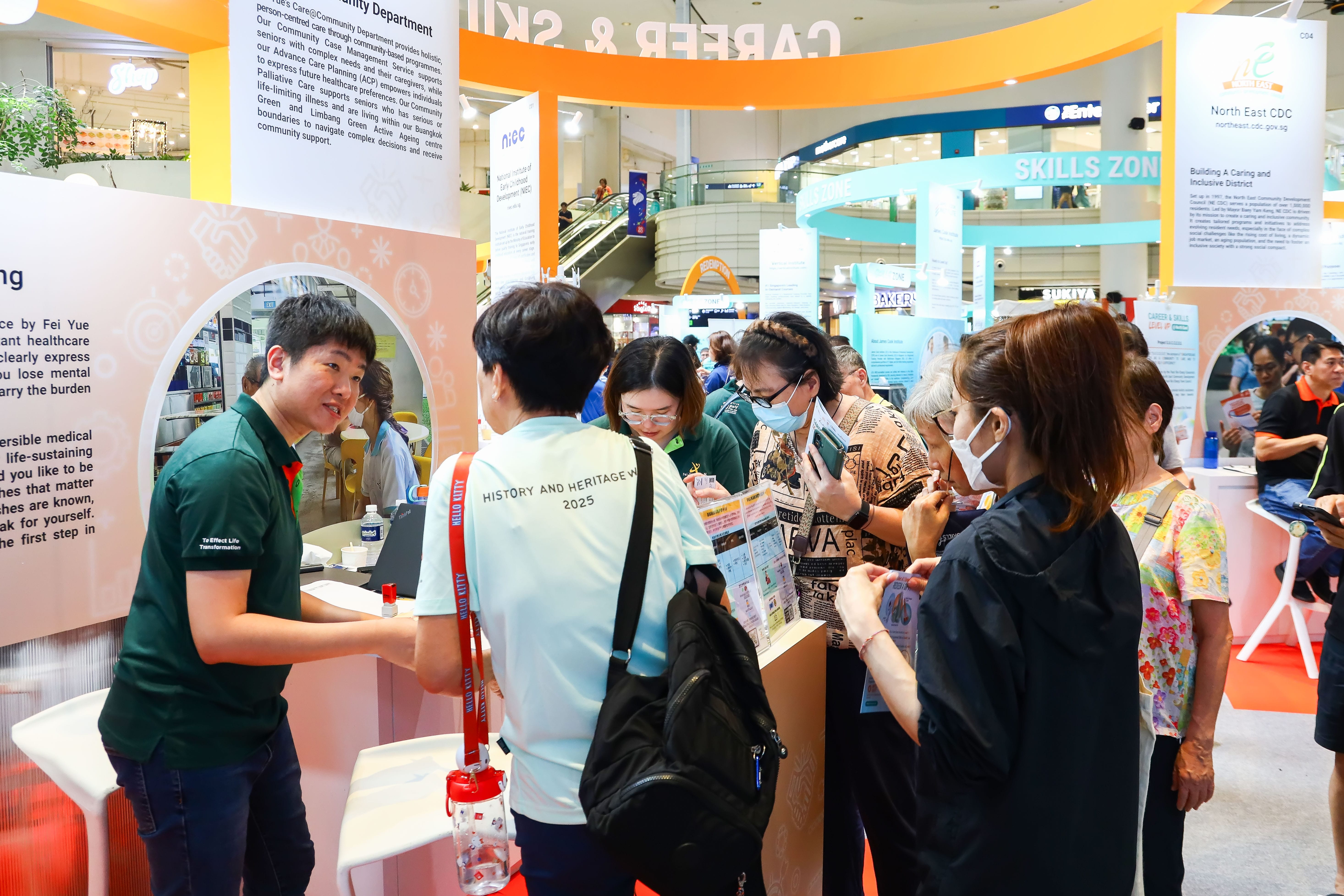 Visitors speaking with staff at an informational booth 