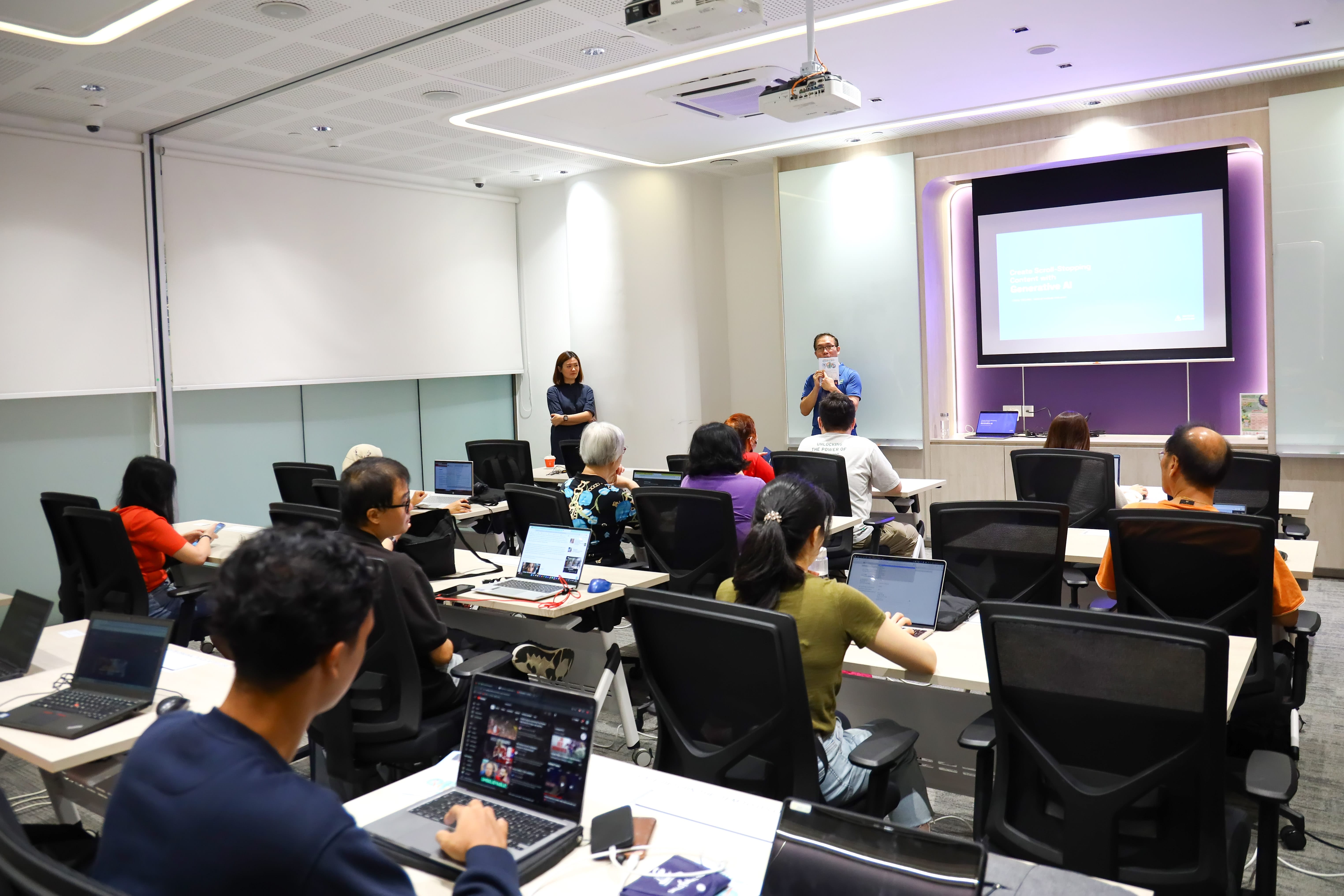 Participants attending a classroom workshop on digital skills while following a presentation at the front of the room