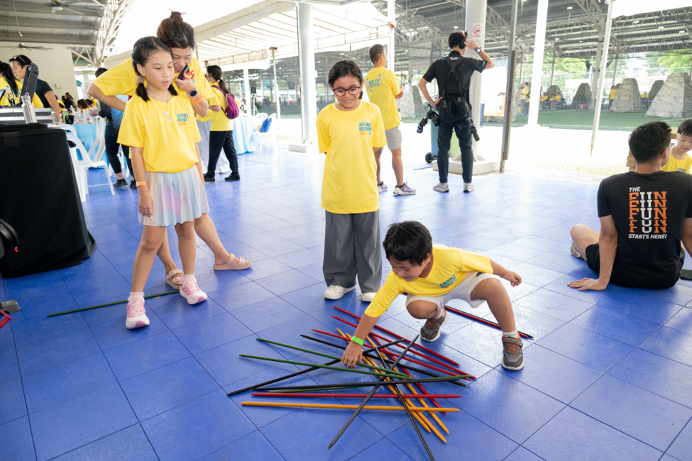 Children playing life-sized pick up sticks