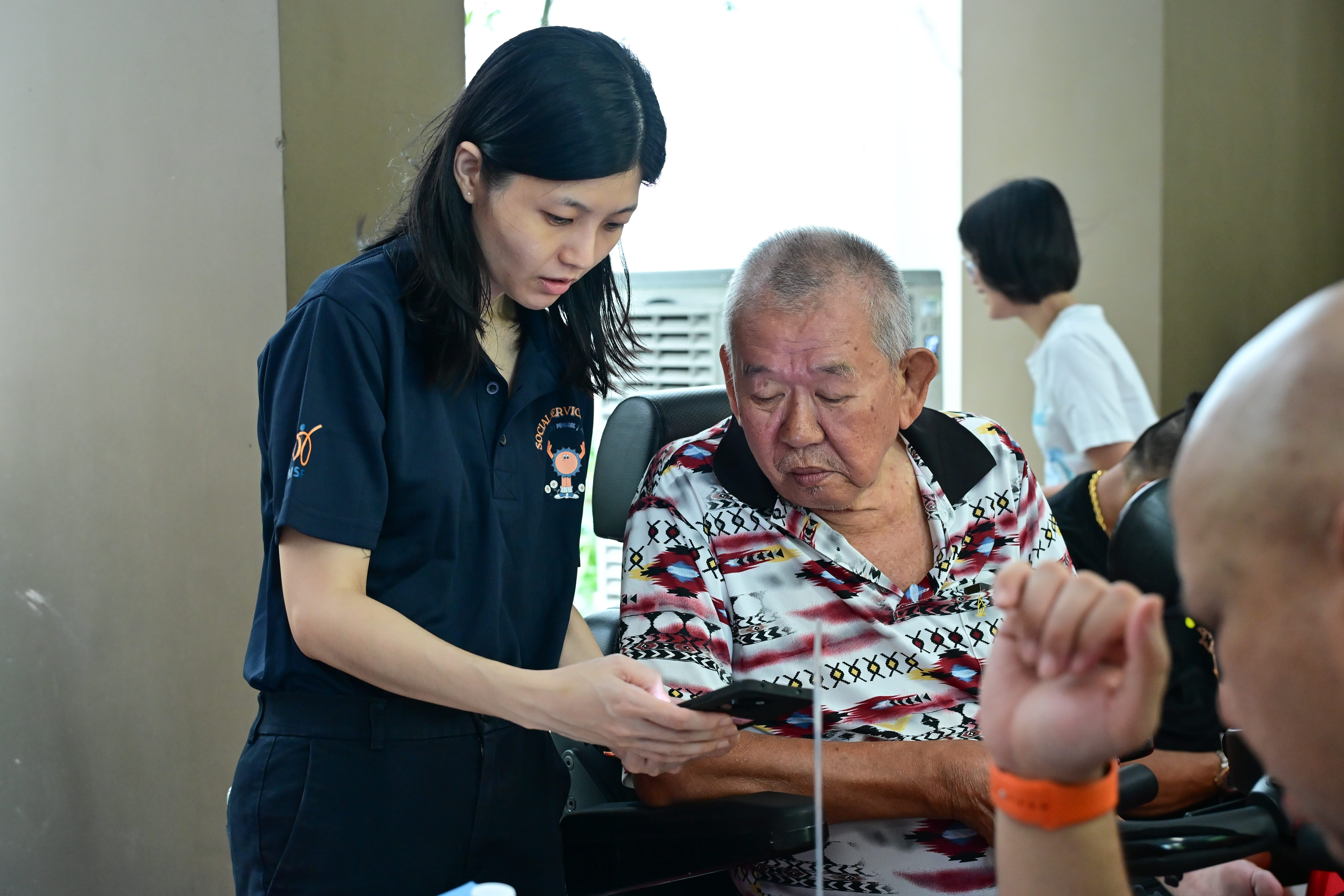 Resident signing up with volunteer's help