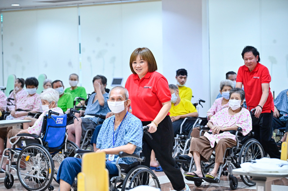 Representatives from Jean Yip helping seniors with moving about