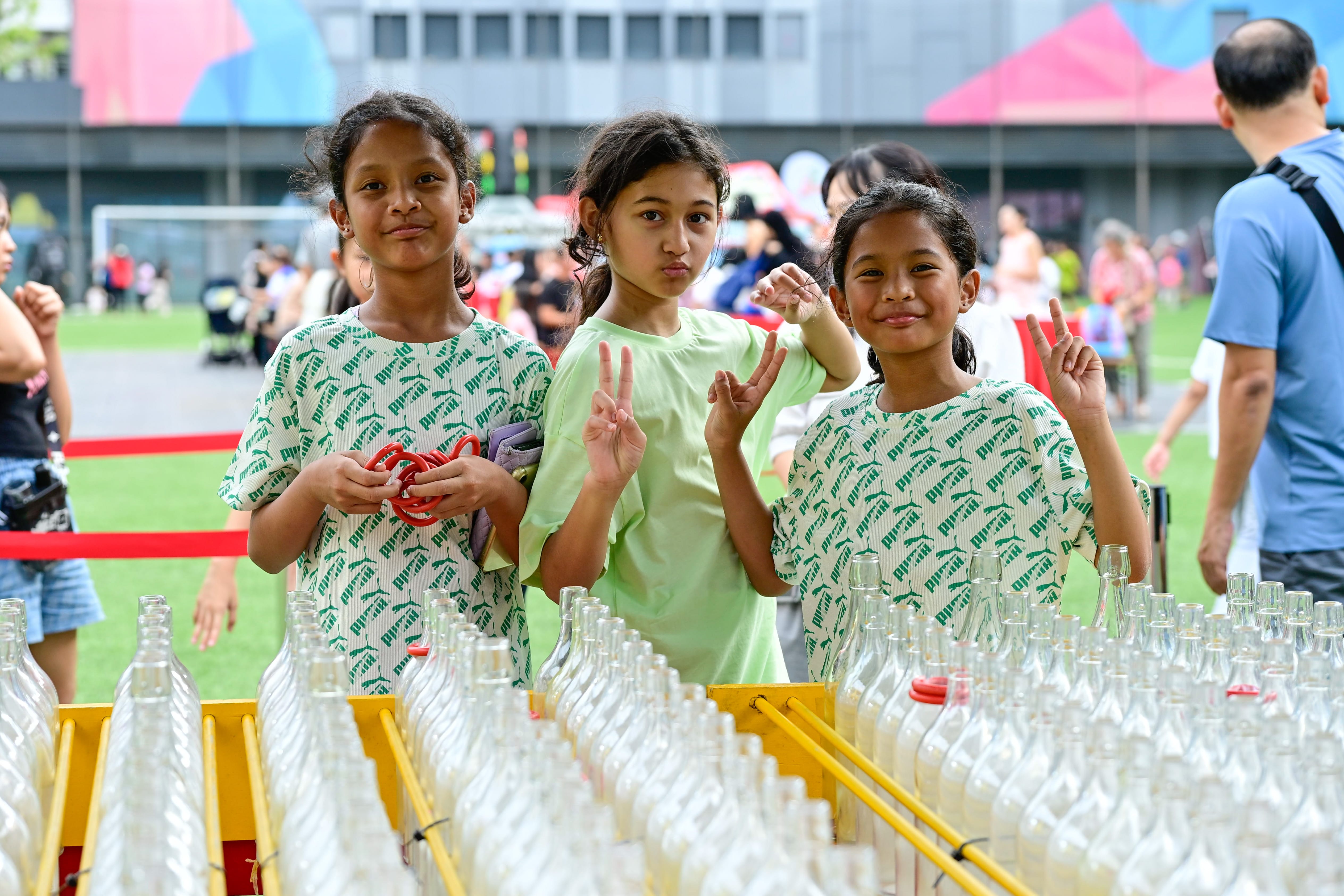 Three smiling young girls standing together for a photograph