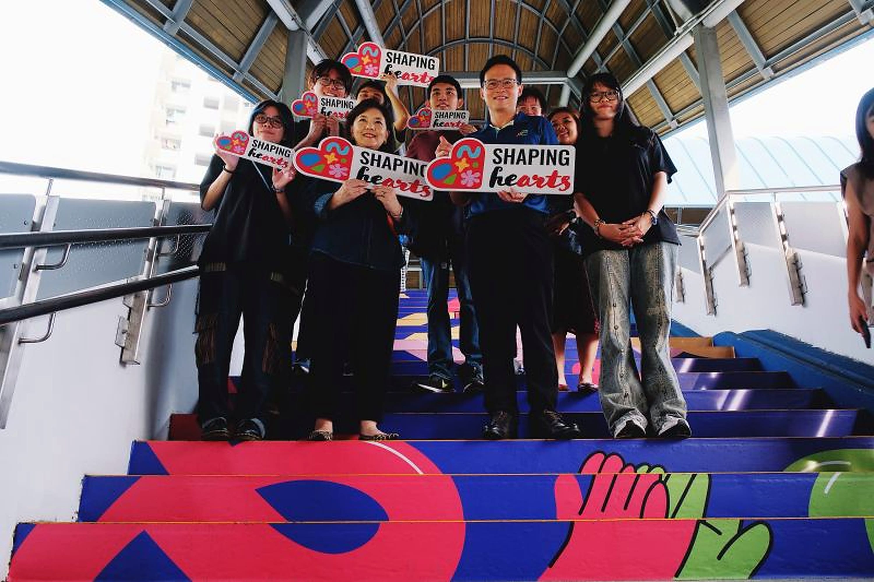 Group photo on the decorated staircase, showing the lower stair graphics and bridge setting.