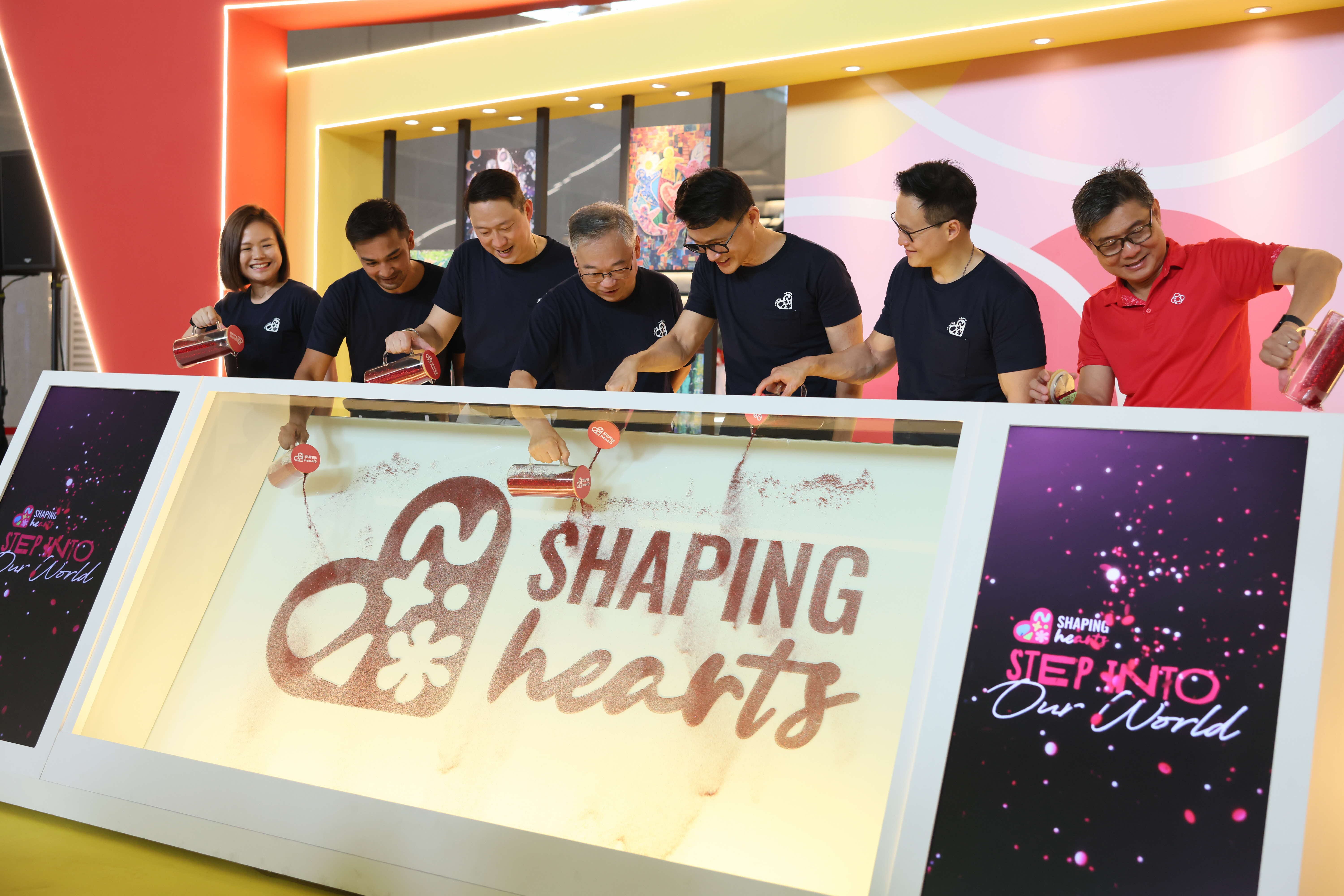 Guests of Honour pouring the red glitter to symbolise the launch of Shaping Hearts 2026