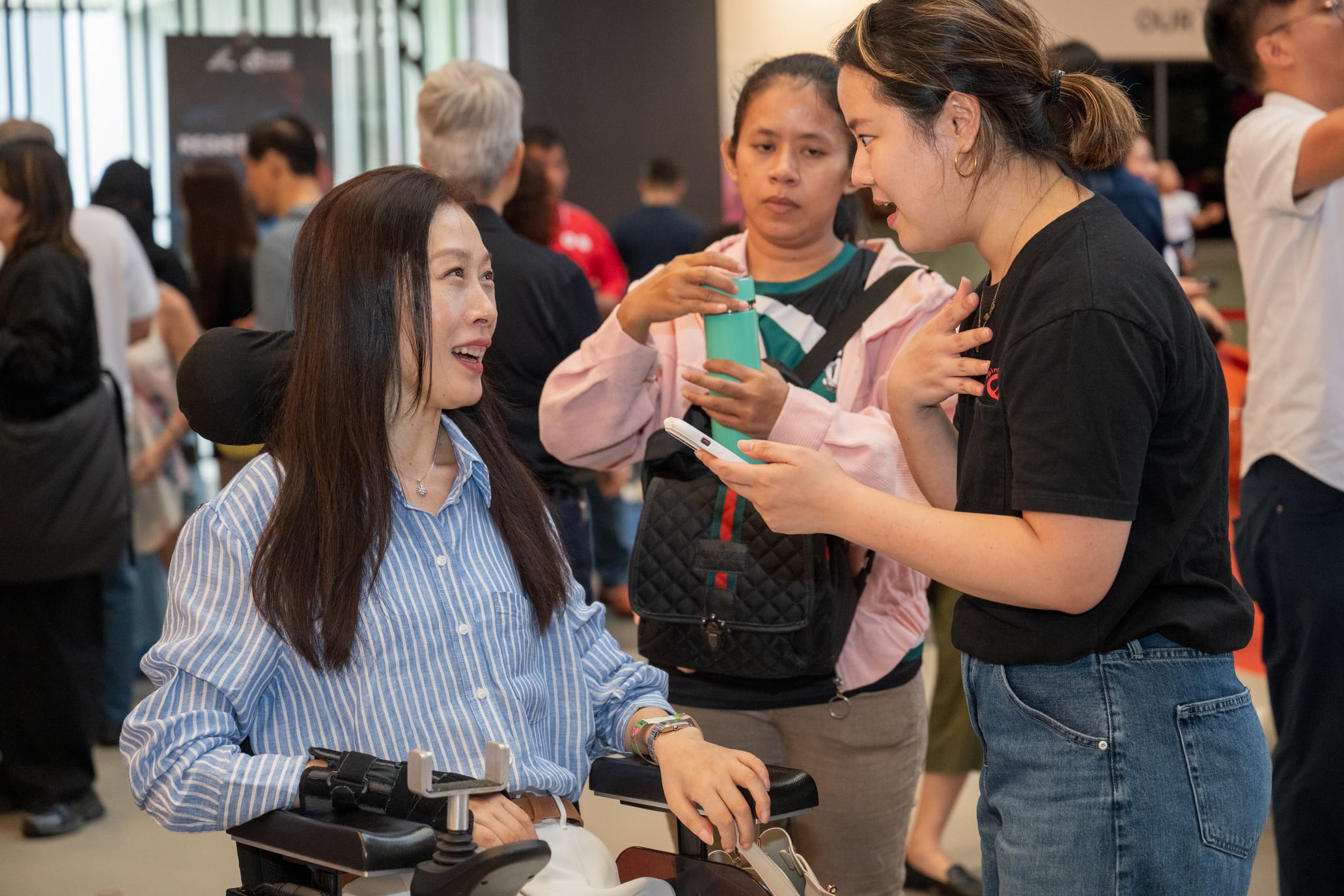 Shaping Hearts staff talking to an artist in a wheelchair.