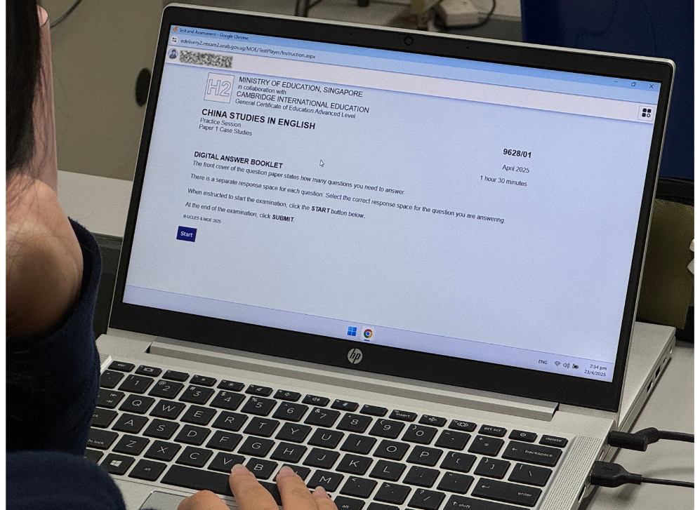 A person is using a laptop displaying an online exam interface for "China Studies in English" with a start button visible.
