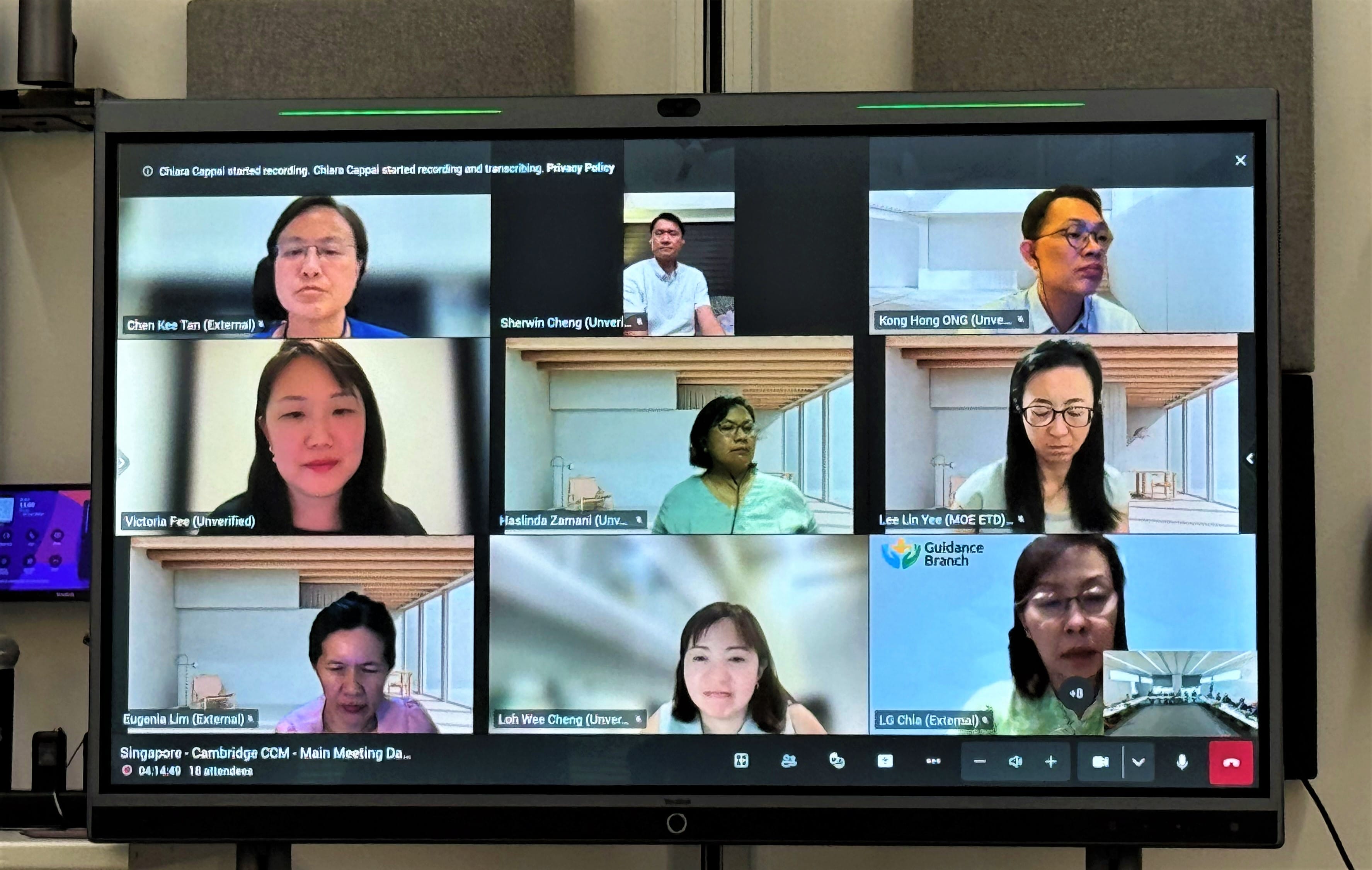 A video conference screen showing 9 participants and a small preview window with the title "Singapore - Cambridge CCM - Main Meeting."