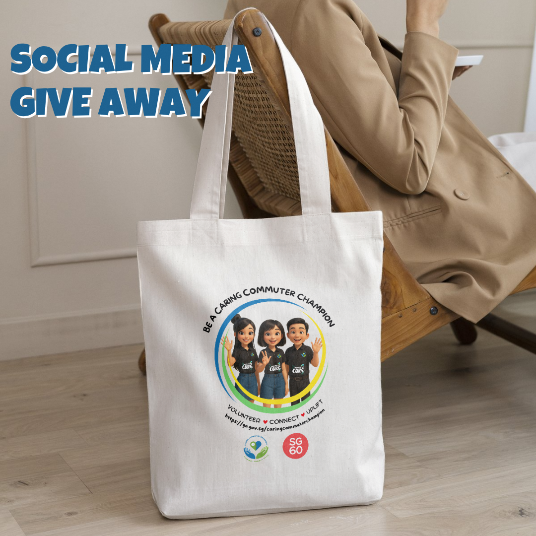 A tote bag printed with three Caring Commuter mascots and the slogan ‘Be a Caring Commuter Champion’, shown hanging on a chair.