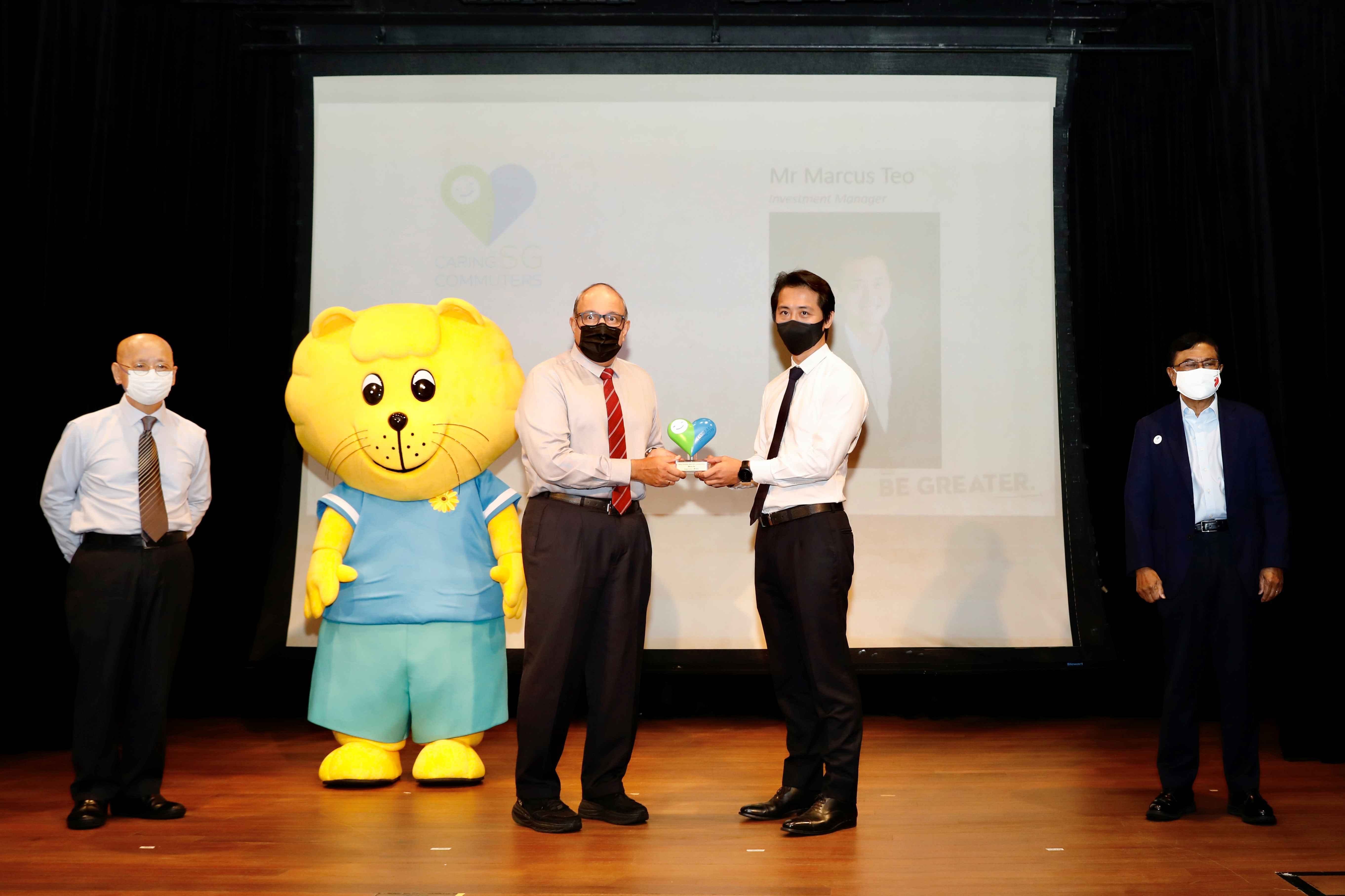 Marcus Teo receives his Caring Commuter Award 2021 (Commendation) on stage during the ceremony.