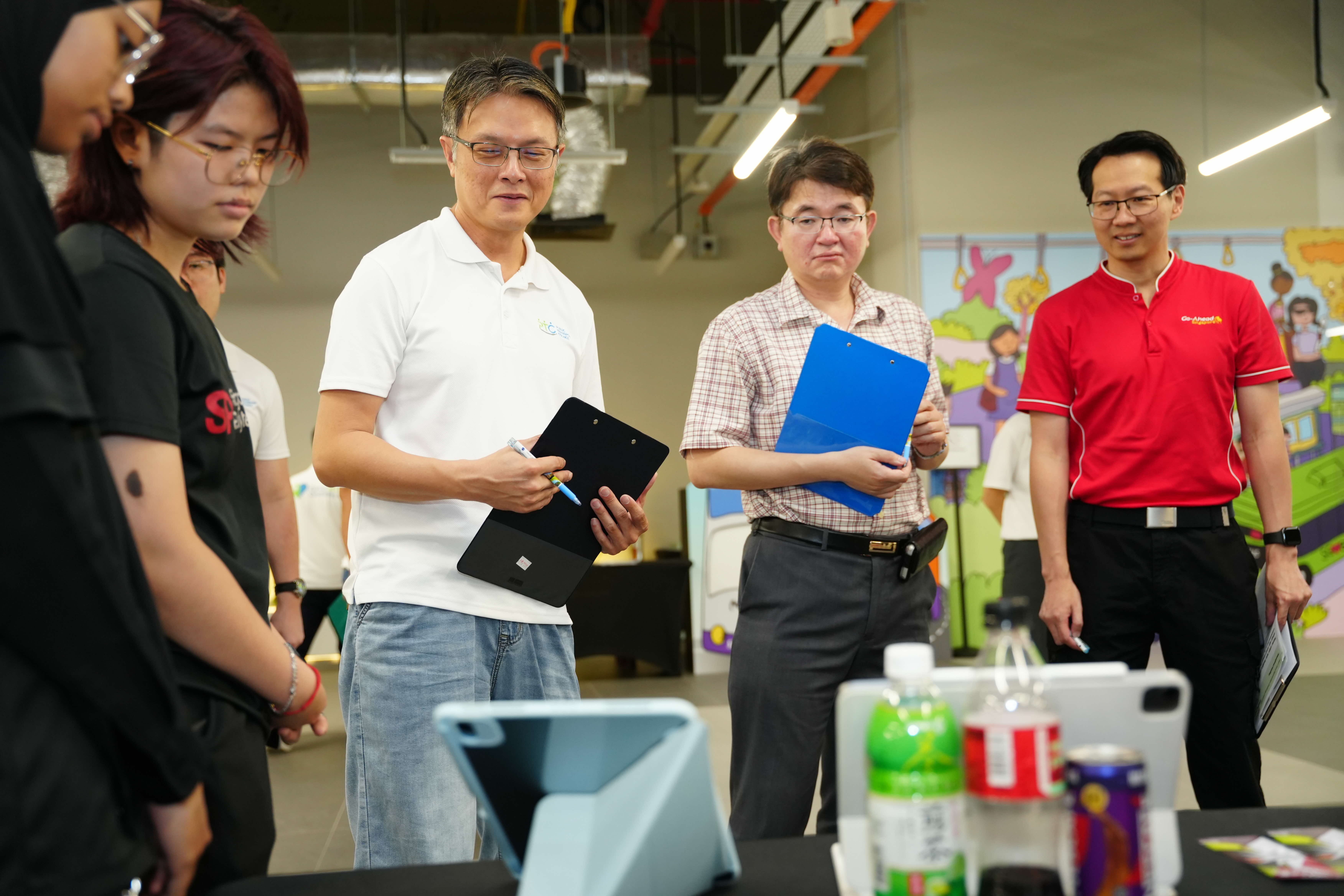 Photo of Mr Leow Yew Chin, Mr Eng Soon Khai and Mr Leonard Lee listening to the presentation of the team.