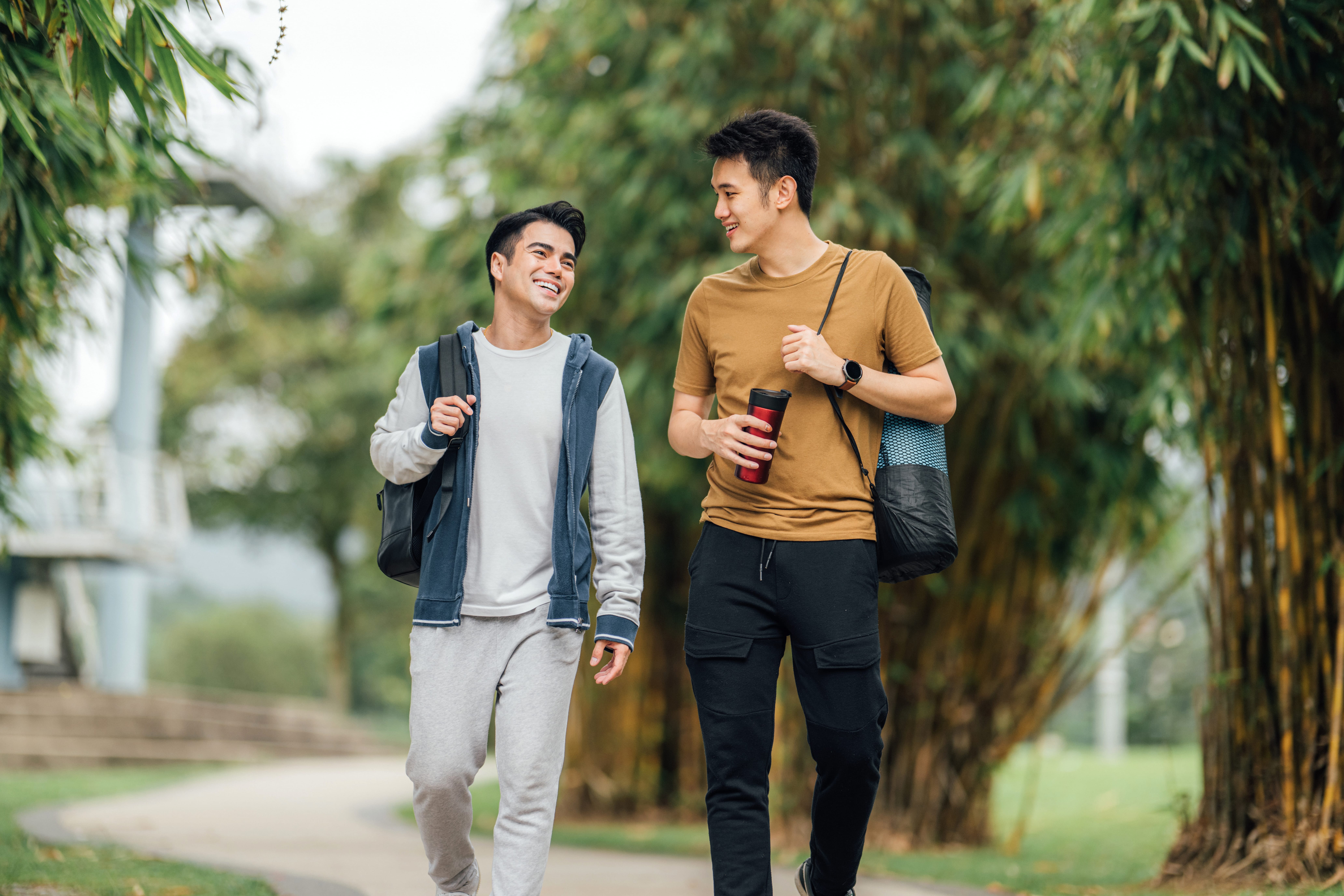 Two men smiling and walking on a path