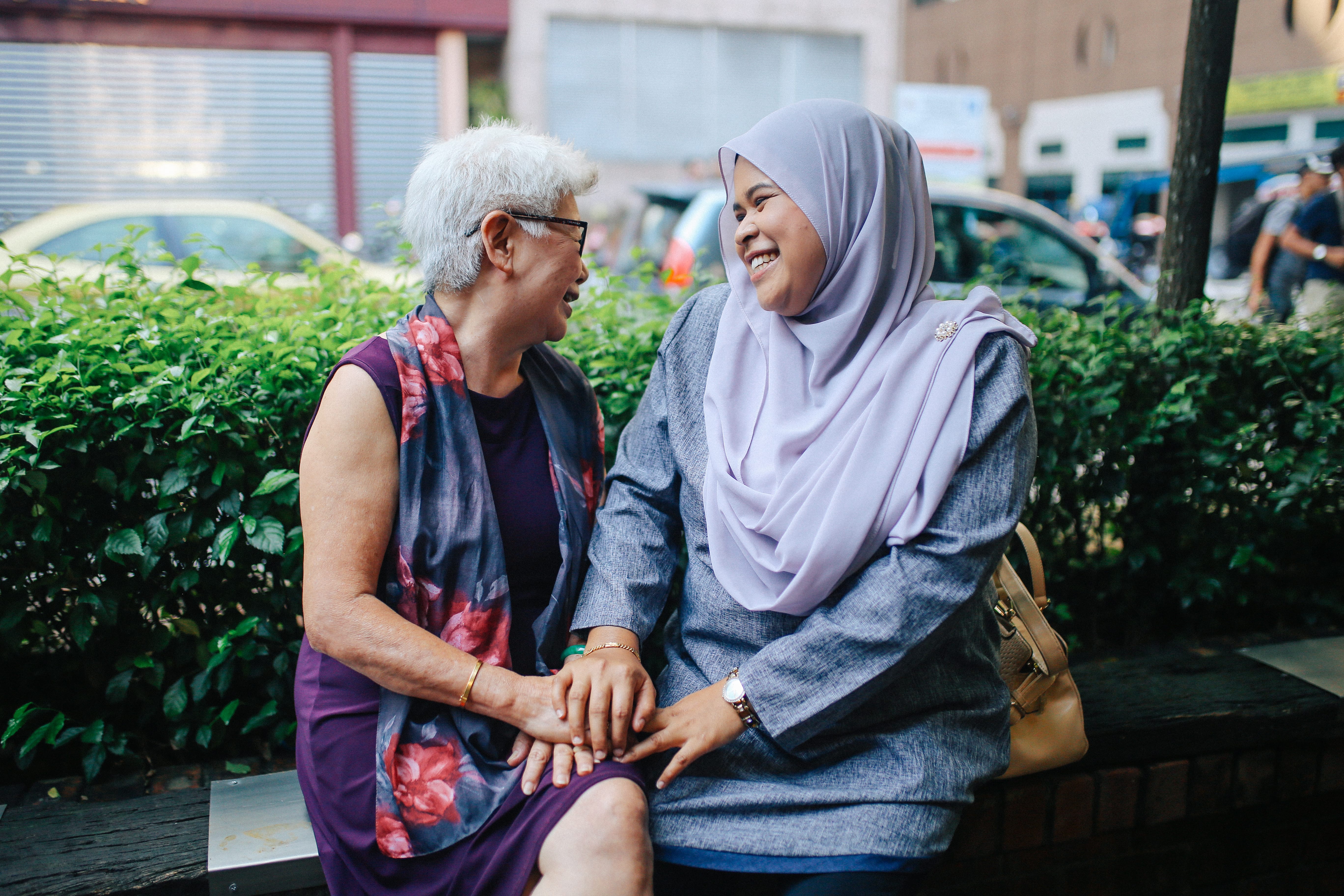 Two ladies of different races smiling at each other