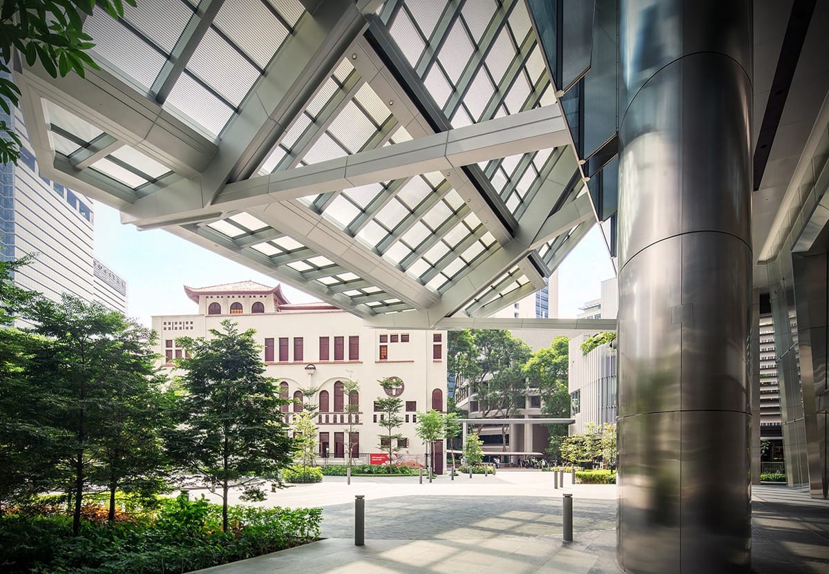 Architectural detail: canopy with steel supports overlooking building and trees.