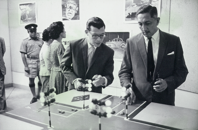 Milton Tan (left), chairman of the Automobile Association of Singapore, showing Yang Di-Pertuan Negara Yusof Ishak around the Road Safety Photographic Exhibition at the Victoria Memorial Hall, 1963. Yusof Ishak Collection, courtesy of National Archives of Singapore.