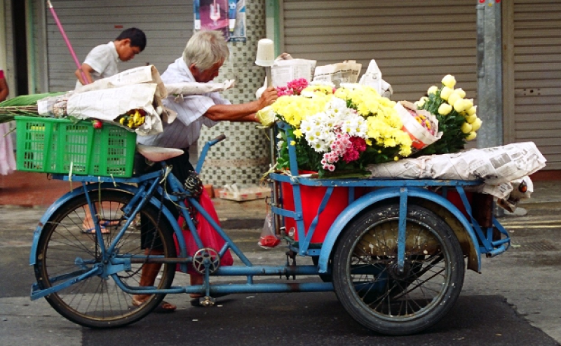 Street vendor transporting fresh flowers from a cargo tricycle, c.2002. Liesel Strauss Collection, National Library, Singapore.