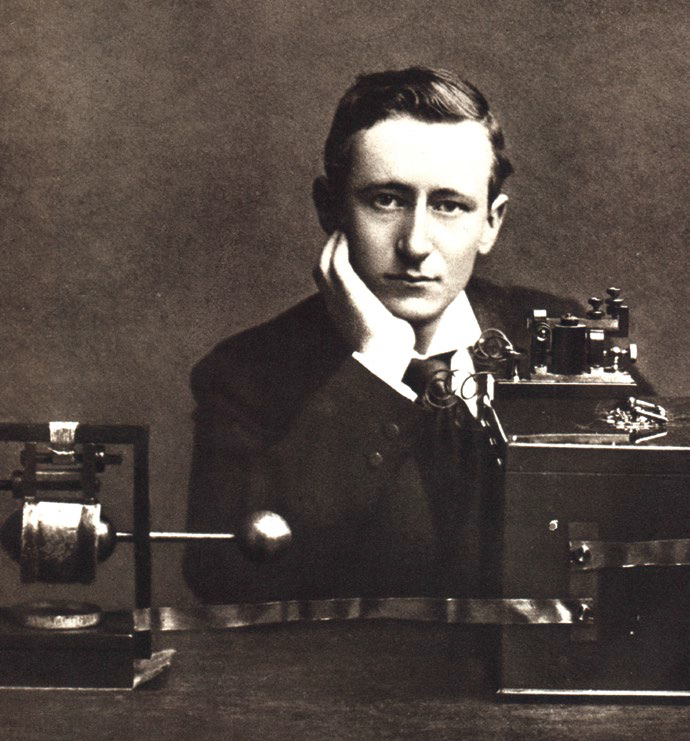 Guglielmo Marconi (1874–1937), Nobel Prize winner and inventor of the radio. He is seen here with his early radio apparatus – the transmitter (left) and the receiver (right). In 1897, Marconi established the Wireless Telegraph & Signal Company Limited (renamed Marconi’s Wireless Telegraph Company in 1900). Creator/photographer unknown. Courtesy of Wikimedia Commons.