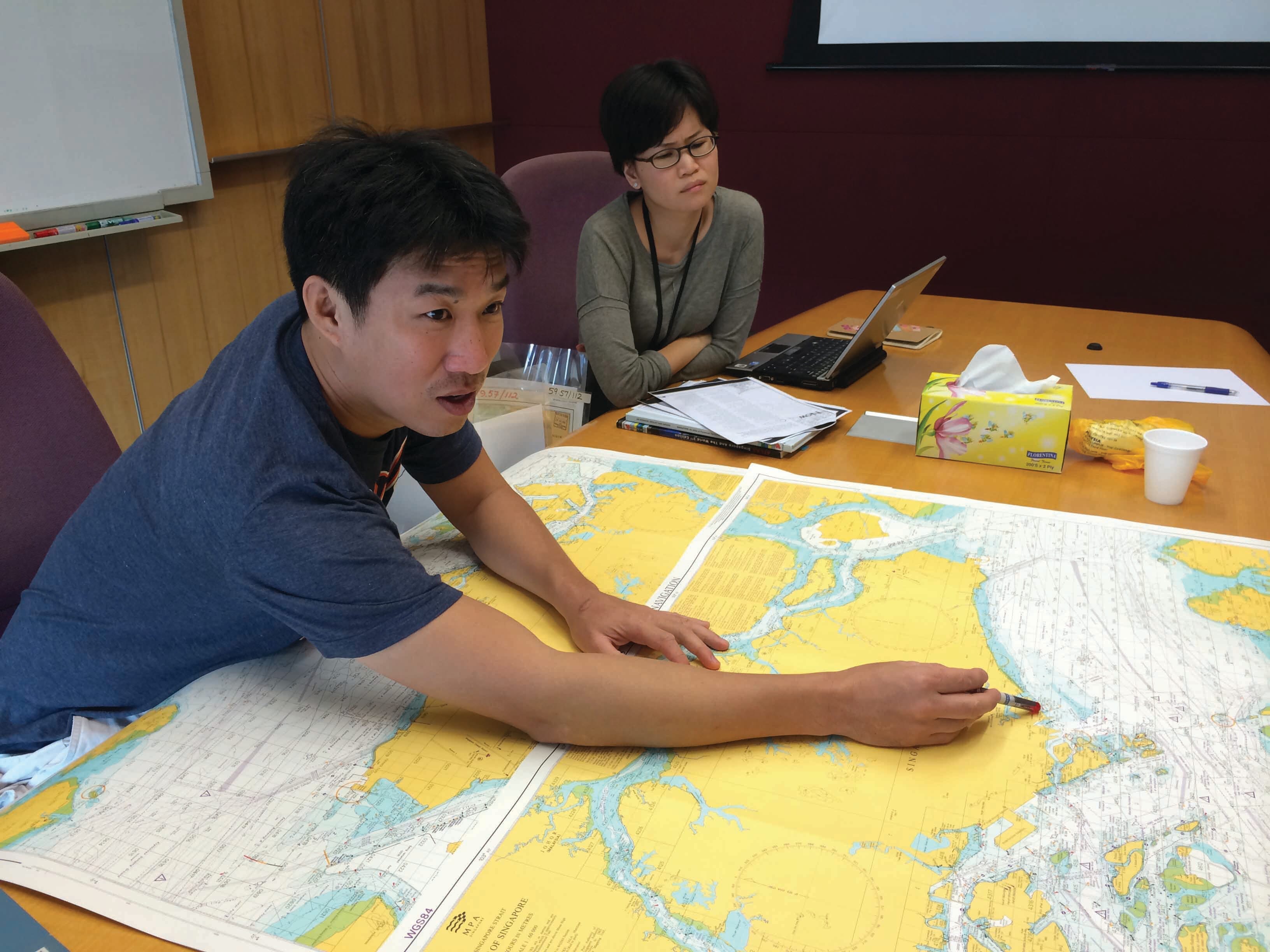 Artist Charles Lim working on seabook with NL librarian, Janice Loo.