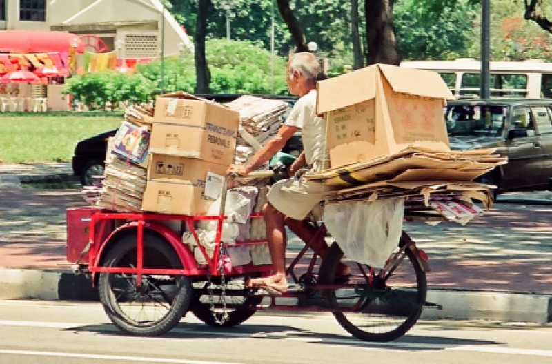 A newspaper and cardboard collector pedalling his cargo tricycle, c.1990. Liesel Strauss Collection, National Library, Singapore.