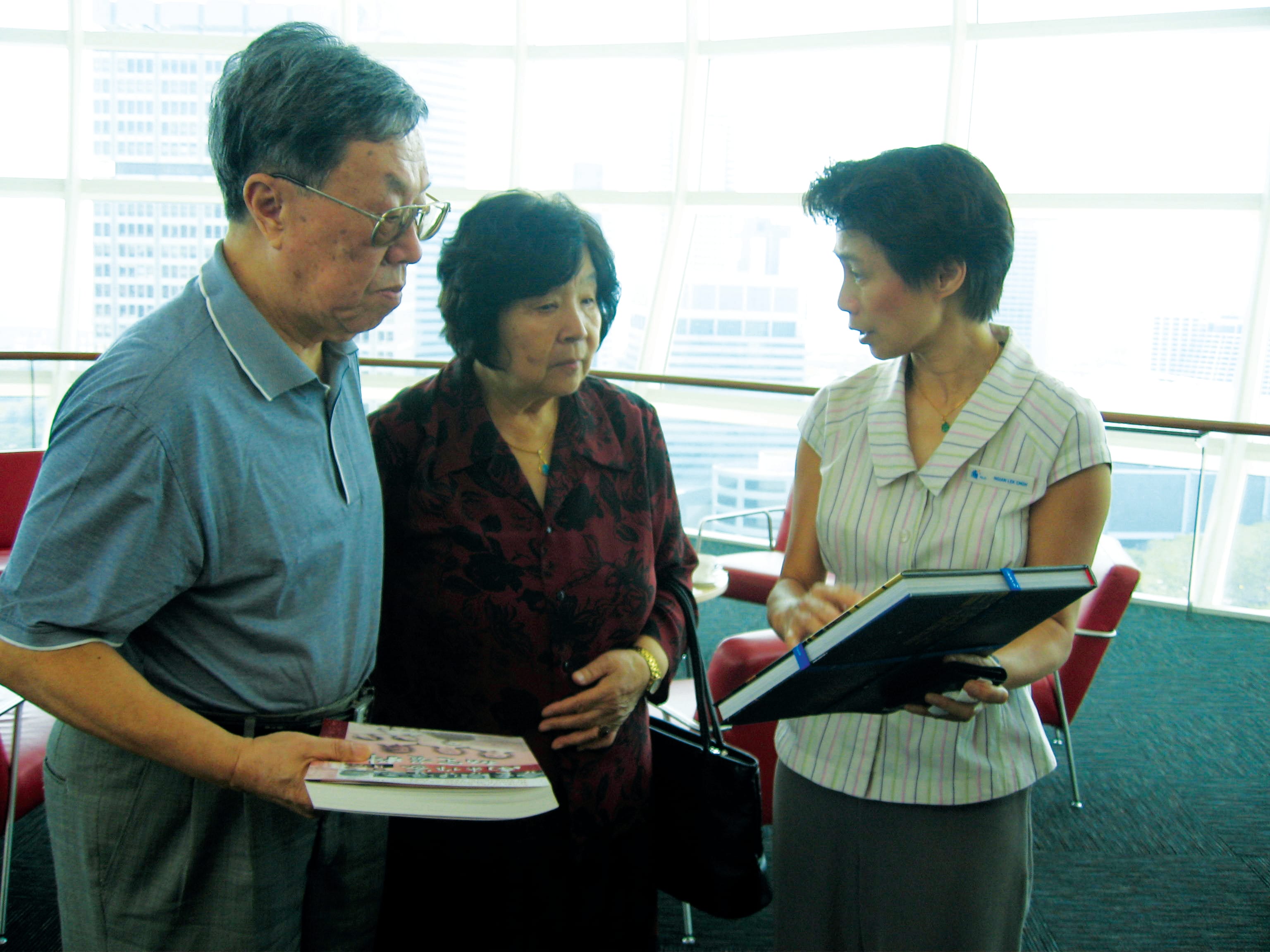 严馆长(右)和王蒙夫妇互赠出版物。