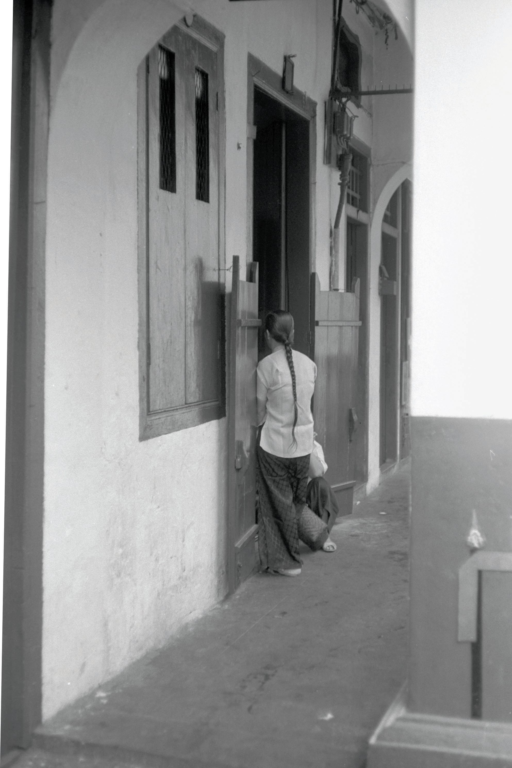 An amah entering a kongsi fong, 1962. Amahs pooled their wages to rent accommodations, known as kongsi fong (公司房), which ranged in size from a cubicle to a shophouse with a number of rooms. Kongsi fong were typically located in tenement blocks in Chinatown. Courtesy of National Archives of Singapore.