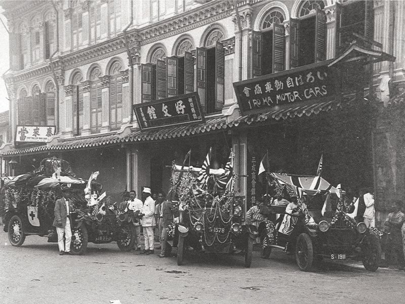 Kobunkan bookstore (2nd shophouse from the right) and Iroha Motor Cars & Co. (extreme right) at 167 and 168 Middle Road respectively, c. 1910s. The handwritten caption behind the photograph reads 英領新架坡 好文館 いろは自動車 山﨑·竹井経営 [泰来當質店] (Eiryō Shingapōru Kōbunkan Iroha Jidōsha Yamasaki·Takei keiei [Tài Lái Dāng Zhìdiàn], which translates as “British-governed Singapore / Kobunkan and Iroha Motor Cars / Managed by Yamsaki & Takei / Chop Thai Loy Pawn Shop”. Courtesy of Tanabe Tsukasa.