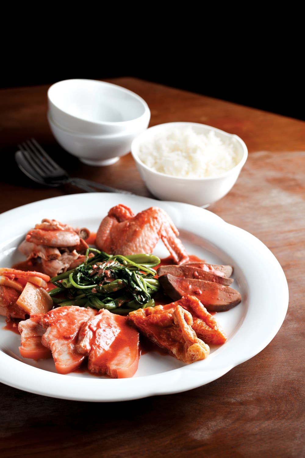 Loh kai yik, or braised chicken wings, is a Cantonese dish made of chicken wings, pork belly, pig’s liver and intestines, ju her (cured cuttlefish), kangkong (water convolvulus) and soya bean puffs. All rights reserved, Tan, S. (2011). Modern Nonya. Singapore: Marshall Cavendish Cuisine.