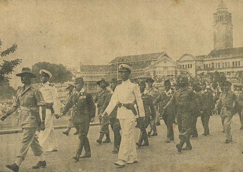 Japanese soldiers led by General Seishiro Itagaki marching towards the Municipal Building (later City Hall) to sign the surrender papers on 12 September 1945. The British Military Administration had announced on 7 September that Tokyo Time would be abolished. The clock tower of the Victoria Theatre and Concert Hall, in the background would have been showing the readjusted time zone of GMT+07:30. Courtesy of the Army Photographic Unit. From National Library Singapore.