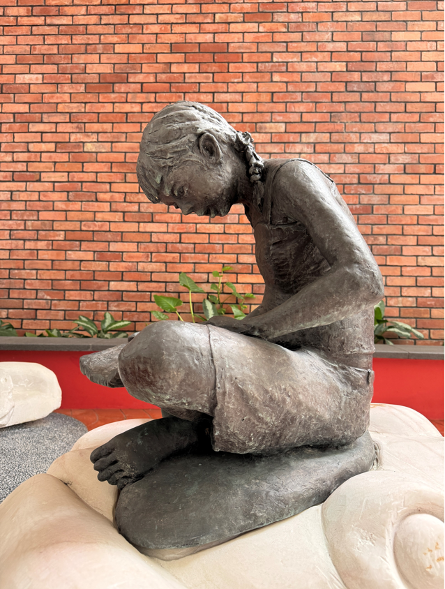 Bricks from the former National Library were used for the wall in the garden of the Central Public Library, 2025. The bronze sculpture of the girl reading is by Singaporean sculptor Chong Fah Cheong. Photo by Jimmy Yap.