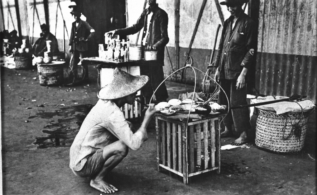 Hawkers balancing their cooking equipment on one end of a pole, with the uncooked food onthe other, were once a common sight. Courtesy of National Archives of Singapore.
