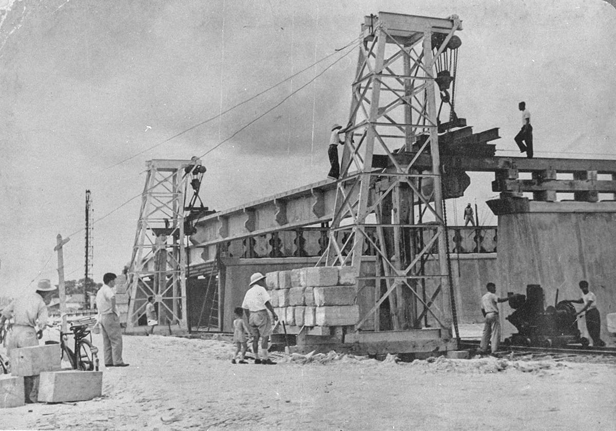 Workers lifting beams into position during the construction of Merdeka Bridge, 1956. Public Works Department Collection, courtesy of National Archives of Singapore (Media - Image No.19980001355 - 0090).