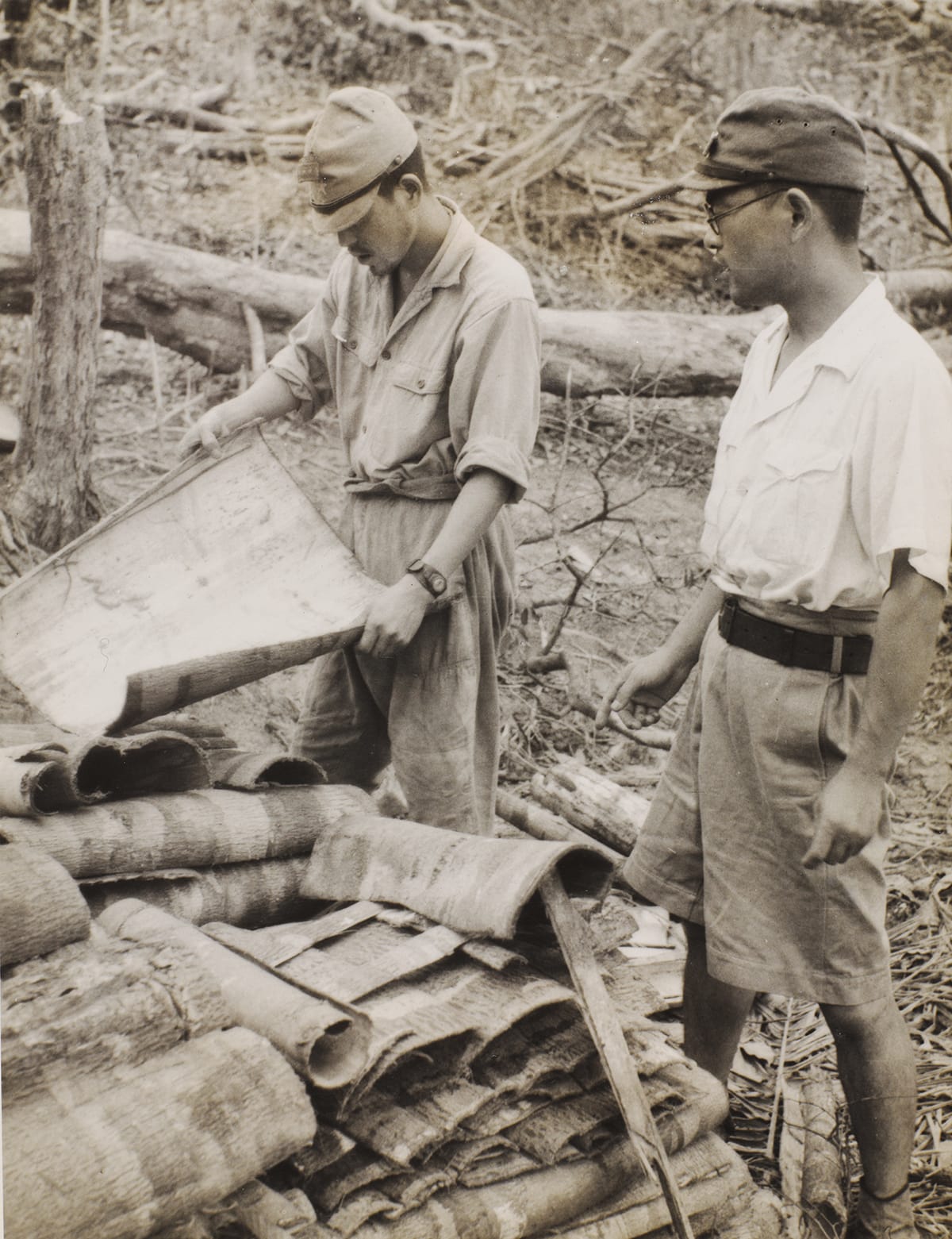 Japanese soldiers stacking tree bark into a pile, 1945. Image courtesy of the National Army Museum, London (NAM. 2009-11-4-4).