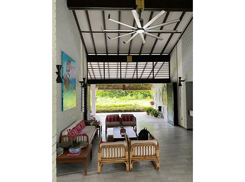 Looking out into the veranda and garden from the living room, which has a very high ceiling, 2023. The large fan gives the living room a cosier feel. Photo by Jimmy Yap.