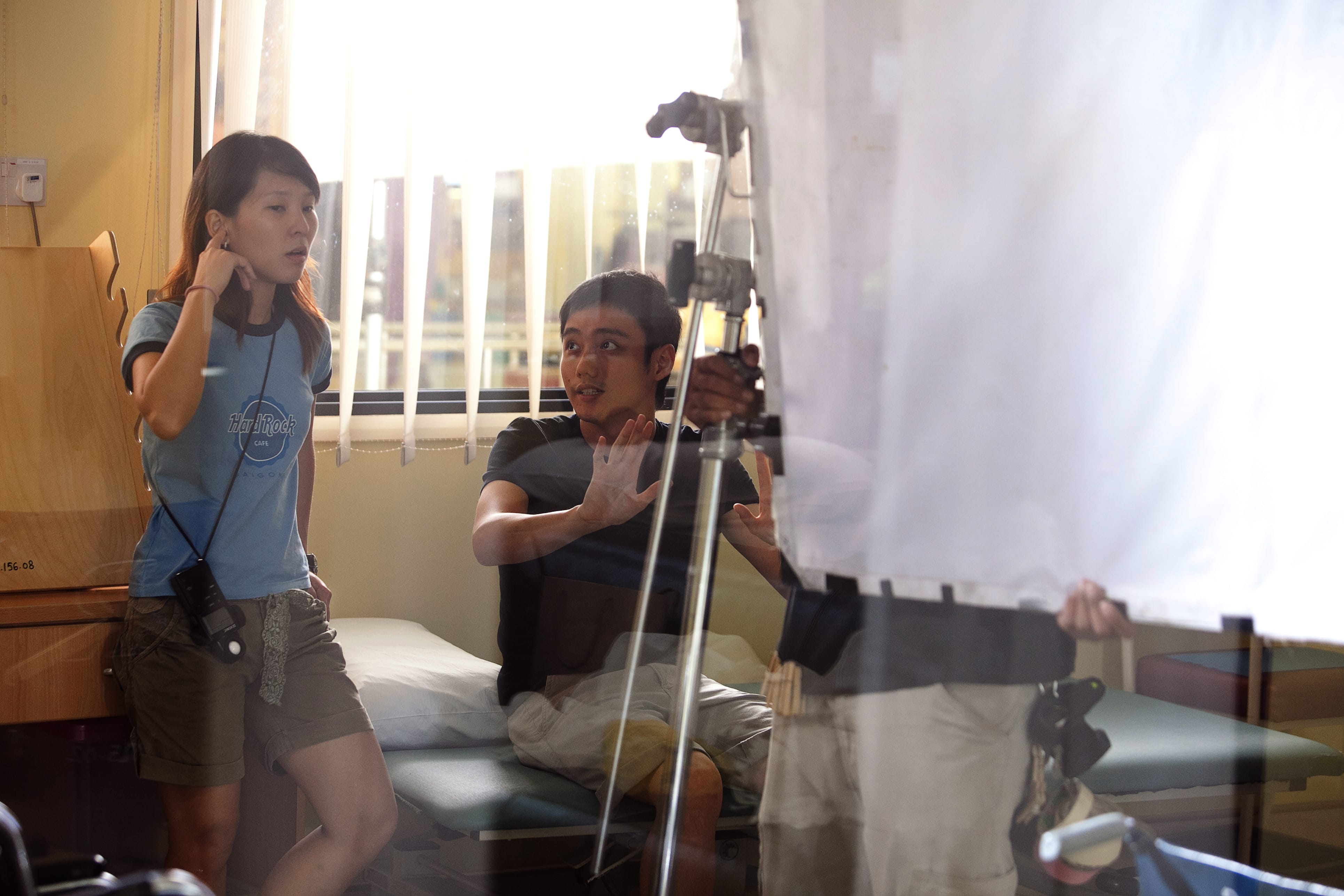 Boo plans a scene with cinematographer Sharon Loh on the set of Sandcastle (2010). All rights reserved, Zhao Wei Films. Courtesy of Boo Junfeng.