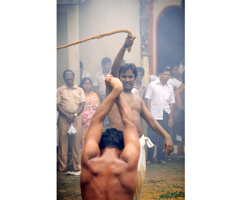 A devotee being whipped to prepare himself for the firewalking at the Sri Mariamman Temple, 1990. Whipping is no longer carried out today. Singapore Tourism Board Collection, courtesy of National Archives of Singapore.