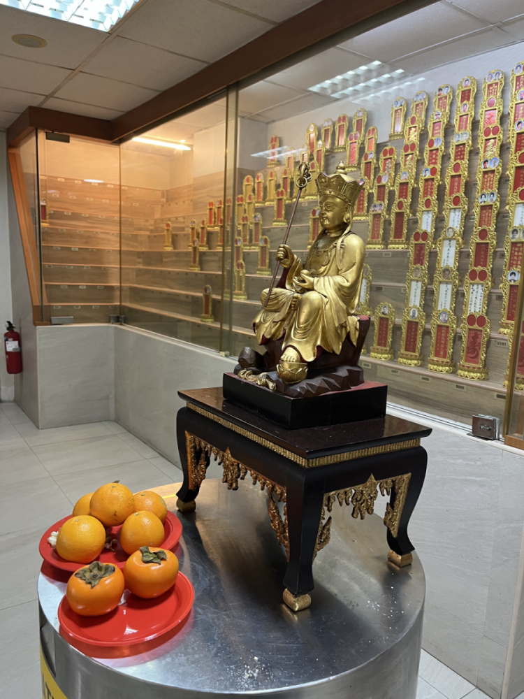 The columbarium with the statute of Kṣitigarbha, the ruler of the underworld, and the ancestral tablets in glass cases, 2023.Photo by Thammika Songkaeo.