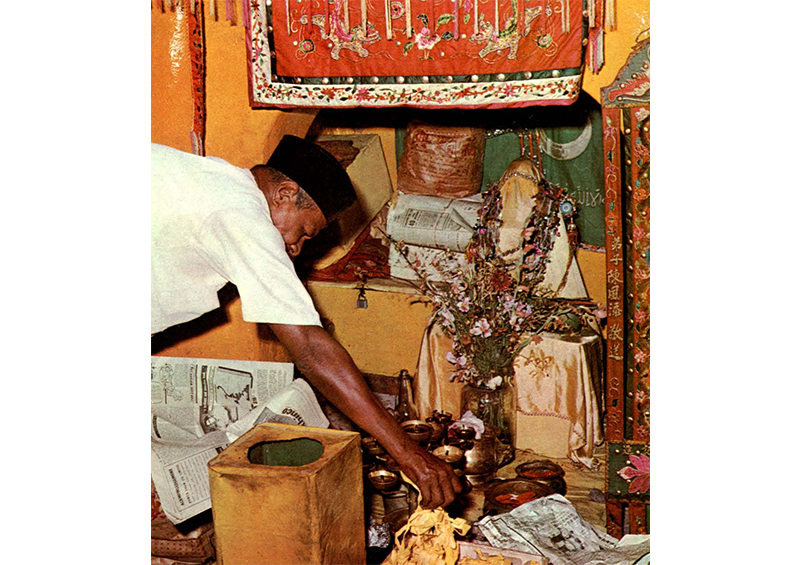 The Malay caretaker placing offerings from devotees at Dato Syed Abdul Rahman’s shrine, 1970. Image reproduced from Goh Tuck Chiang, “Picnic With the Harbour Gods,” Straits Times Annual, 1 January 1970, 66–67. (From NewspaperSG).
