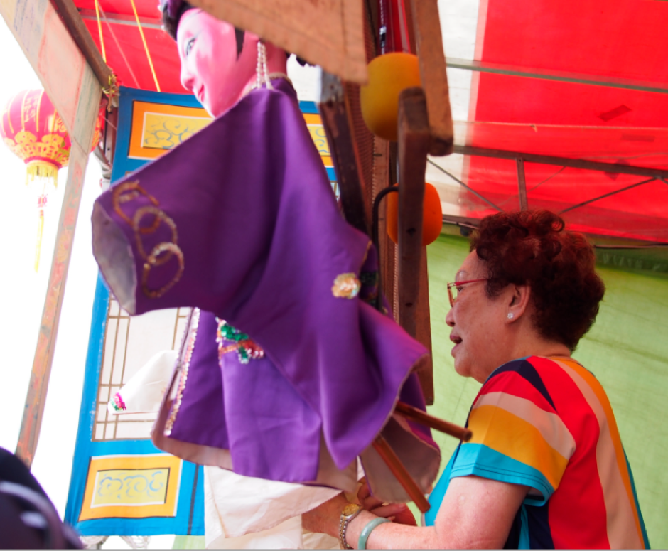 Hainanese rod puppet troupe San Chun Long’s performance at the Yan Kit Village Chinese Temple in November 2015. The rods are partially obscured from view by the puppet’s costume. Photo by Jace Tan, National Heritage Board Puppetry Documentation Project 2015/2016.