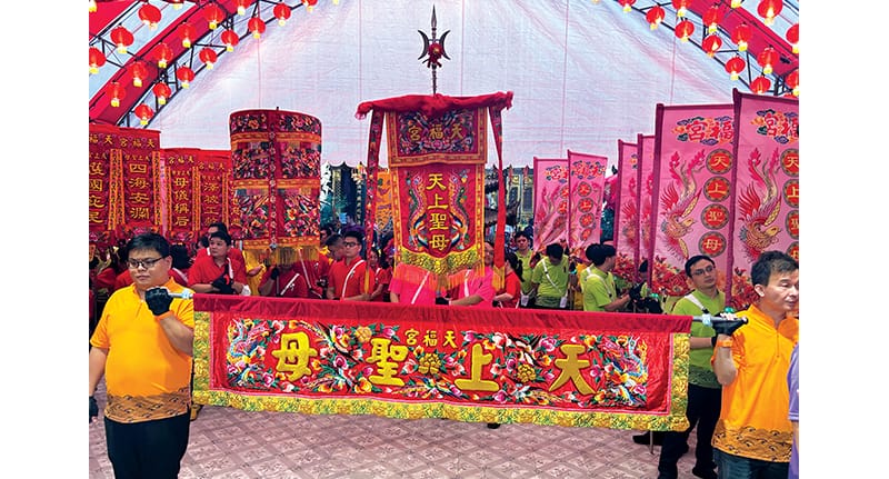 The horizontal cloth banner embroidered with Mazu’s title, 天上圣母 (Holy Heavenly Mother). Photo by Daryl Lim Wei Jie.