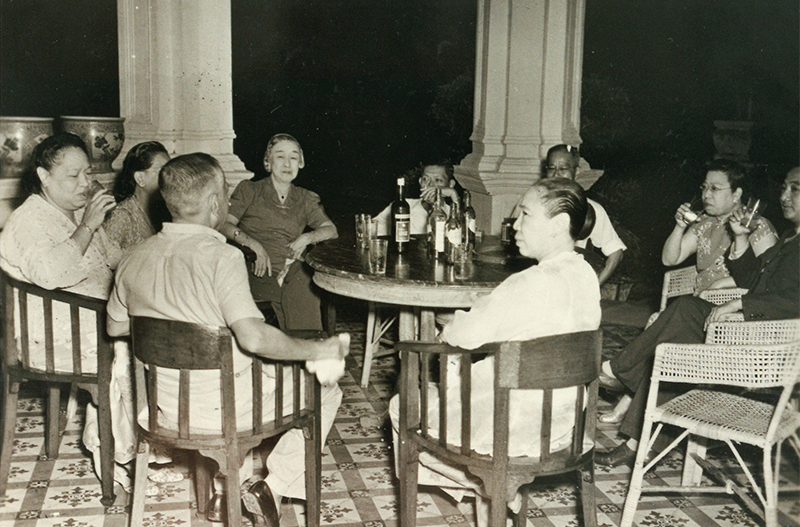 Guests having drinks with Mrs Lee Choon Guan in her favourite spot on the front verandah of Mandalay Villa, c. 1950. Courtesy of Mrs Alice Chua.