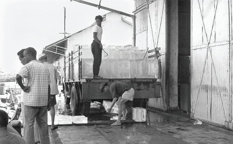 Workers loading large ice blocks, meant for fishing companies, onto a lorry using sharp hooks, 1960s. The ice helped to keep catches fresh while out at sea. Primary Production Department Collection, courtesy of National Archives of Singapore.