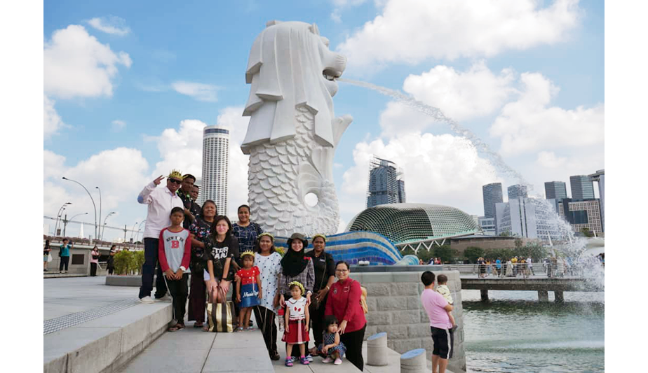 Posing for the obligatory Merlion photo at the Merlion Park, 2019. Some of the Orang Seletar are wearing their tajak (headdress). Photo courtesy of Jefree bin Salim.